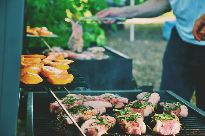 Grilling meat and vegetables outdoors, showcasing a classic American barbecue, popular with travelers visiting the U.S.
