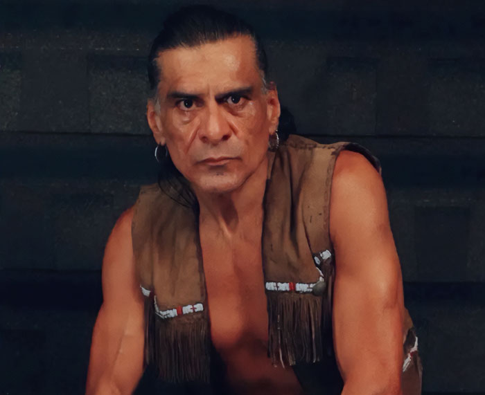 Actor with long hair and earrings wearing a fringe vest, representing one of the stars lost this year.