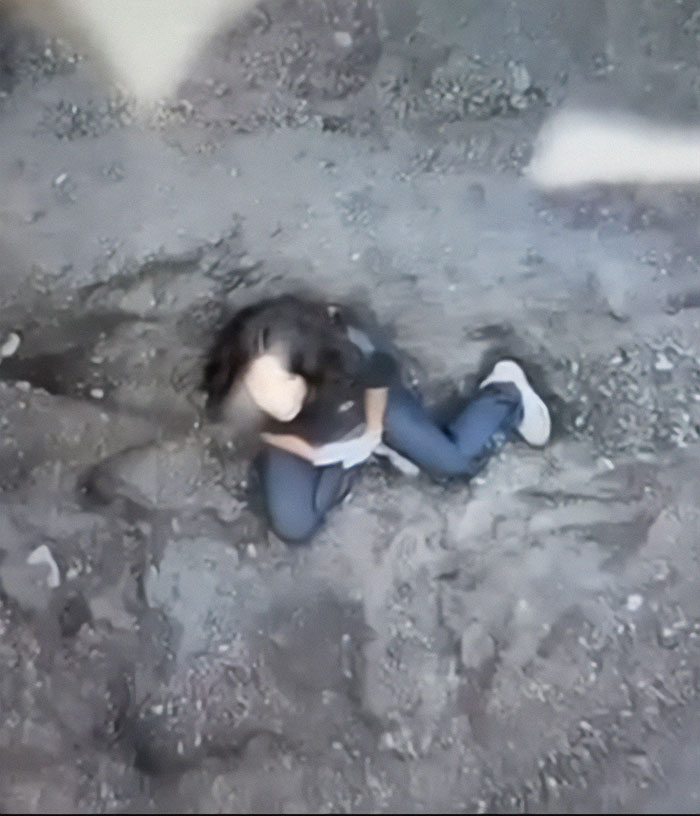 Woman sitting on rocky ground inside an active volcano, related to hiker abandoned 1600ft by her guide.