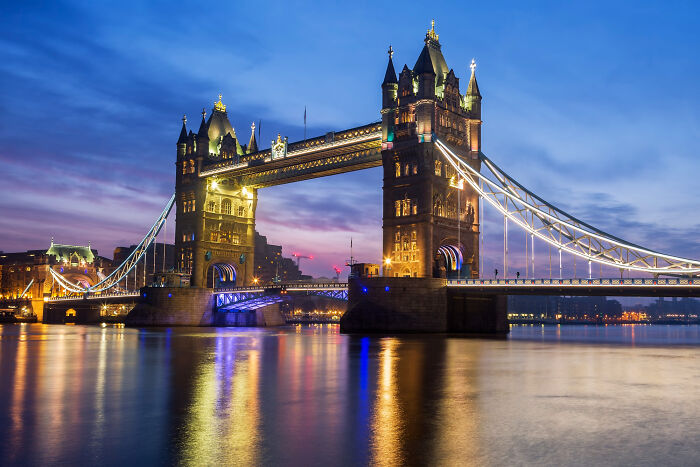 Illuminated Tower Bridge in London at dusk, symbolizing moments of bravery that changed the course of history. - 7