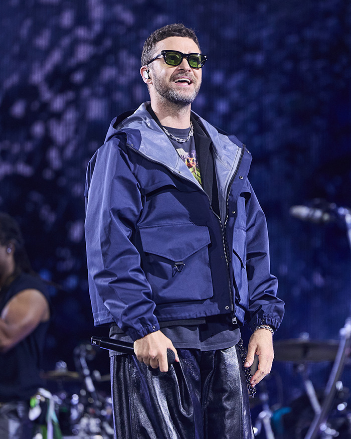 Justin Timberlake performing on stage, wearing sunglasses and a navy jacket, revealing Lyme disease battle in recent post. - 1