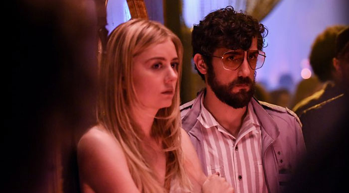 Justine Lupe in a dramatic screen performance with a male co-star in a dimly lit, intense scene.