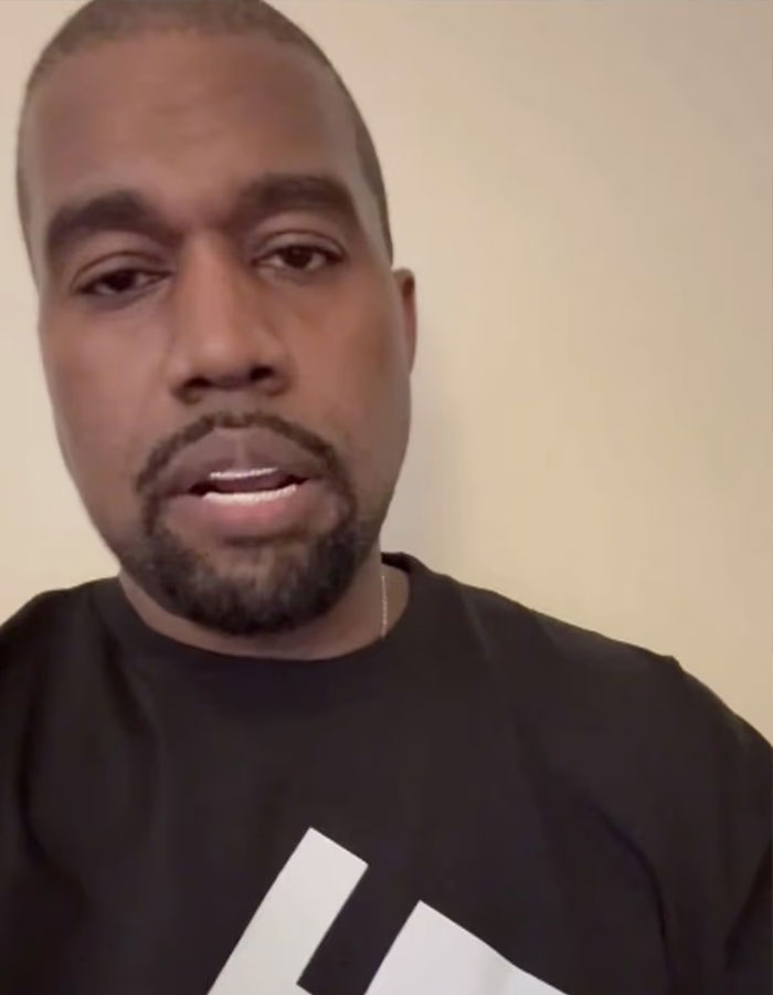 Kanye West speaking in a casual black shirt with a light background in an indoor setting. Kanye West speaking in a casual black shirt with a light background in an indoor setting.