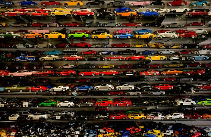 Collection of colorful toy cars displayed on shelves representing trends contributing to overconsumption in society. - 29