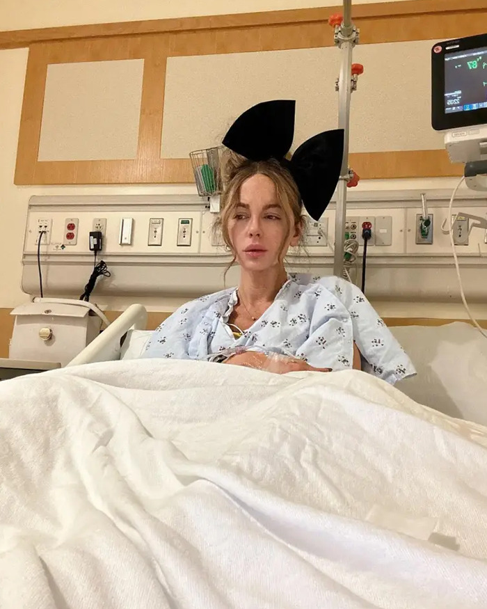 Kate Beckinsale in hospital gown with a large black bow, showing drastic weight loss and a very thin appearance. Kate Beckinsale in hospital gown with a large black bow, showing drastic weight loss and a very thin appearance.