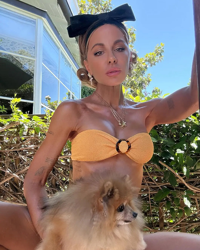 Kate Beckinsale in a yellow bikini top with a black bow headband showing drastic weight loss and a thin look outdoors with a small dog. Kate Beckinsale in a yellow bikini top with a black bow headband showing drastic weight loss and a thin look outdoors with a small dog.