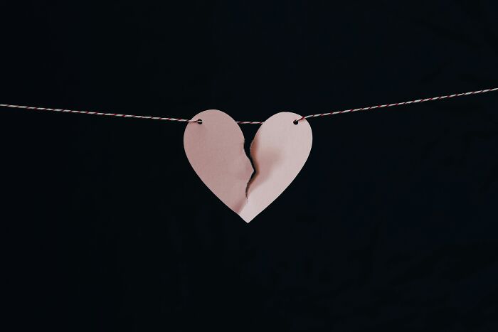 Torn paper heart hanging on a string against a dark background, symbolizing people share things that improved life. - 28