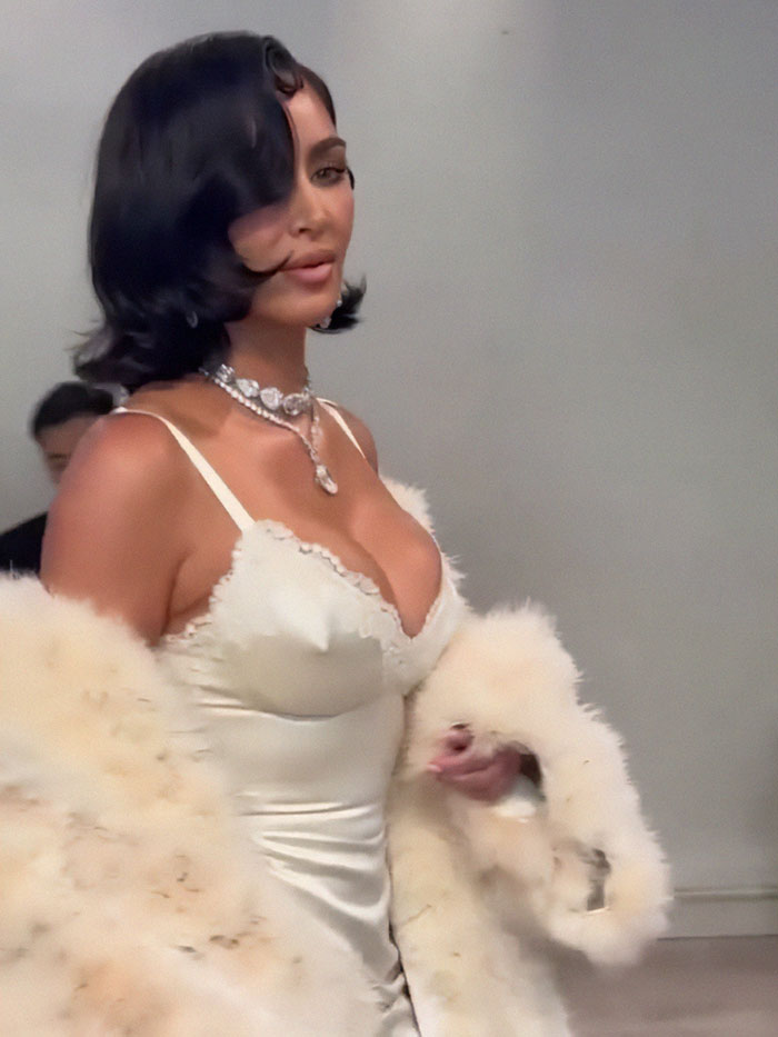 Kim Kardashian in a white dress and fur coat walking the runway, sparking constipated runway walk comments at Paris Fashion Week. Kim Kardashian in a white dress and fur coat walking the runway, sparking constipated runway walk comments at Paris Fashion Week.