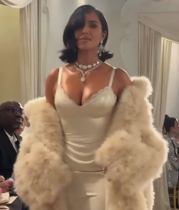 Kim Kardashian walking runway at Paris Fashion Week 2025 wearing a cream dress and fur coat amid runway walk criticism. Kim Kardashian walking runway at Paris Fashion Week 2025 wearing a cream dress and fur coat amid runway walk criticism.