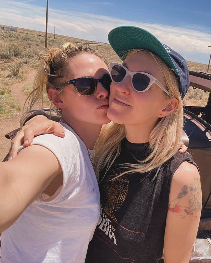 Kristen Stewart wearing sunglasses with new wife outdoors, showing a dramatic transformation during a sunny day. Kristen Stewart wearing sunglasses with new wife outdoors, showing a dramatic transformation during a sunny day.