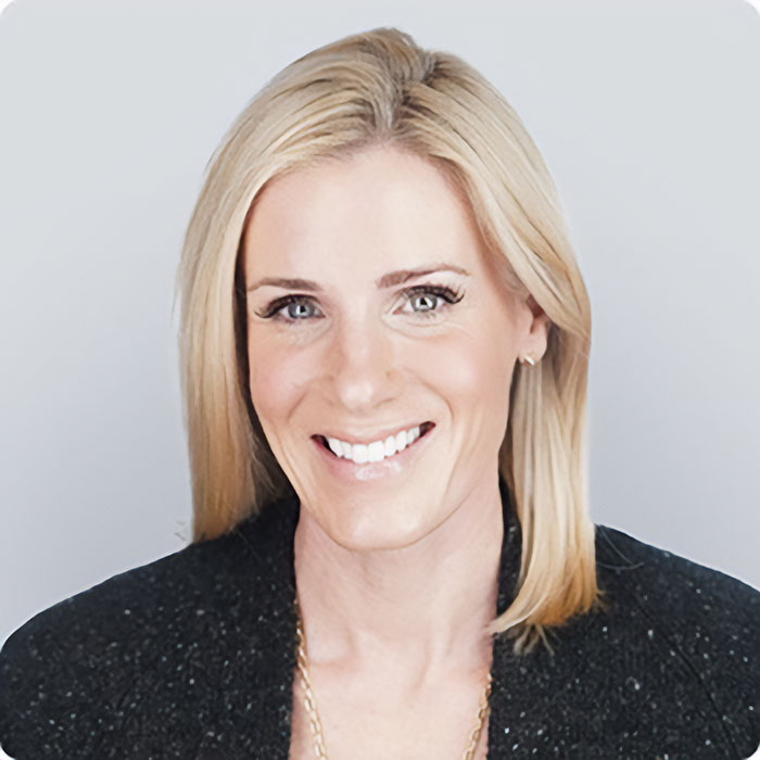 Blonde HR executive smiling in professional attire, highlighting past and elite sorority days in Coldplay context.