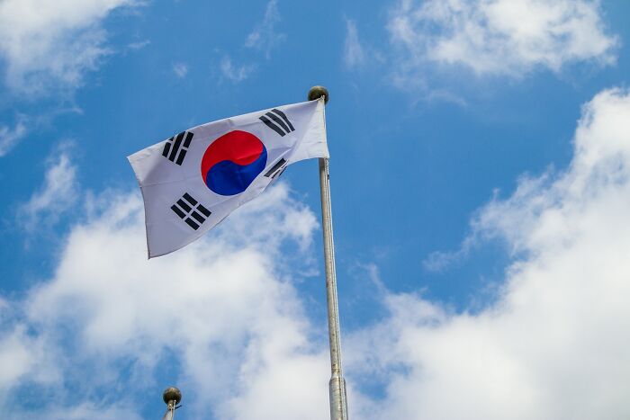 South Korea flag waving on a tall flagpole against a blue sky, illustrating interesting rumors that turned out true.