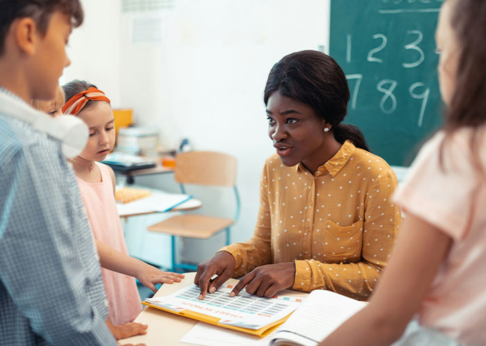 US teacher engaging with elementary students about literacy, highlighting concerns over the growing literacy crisis.