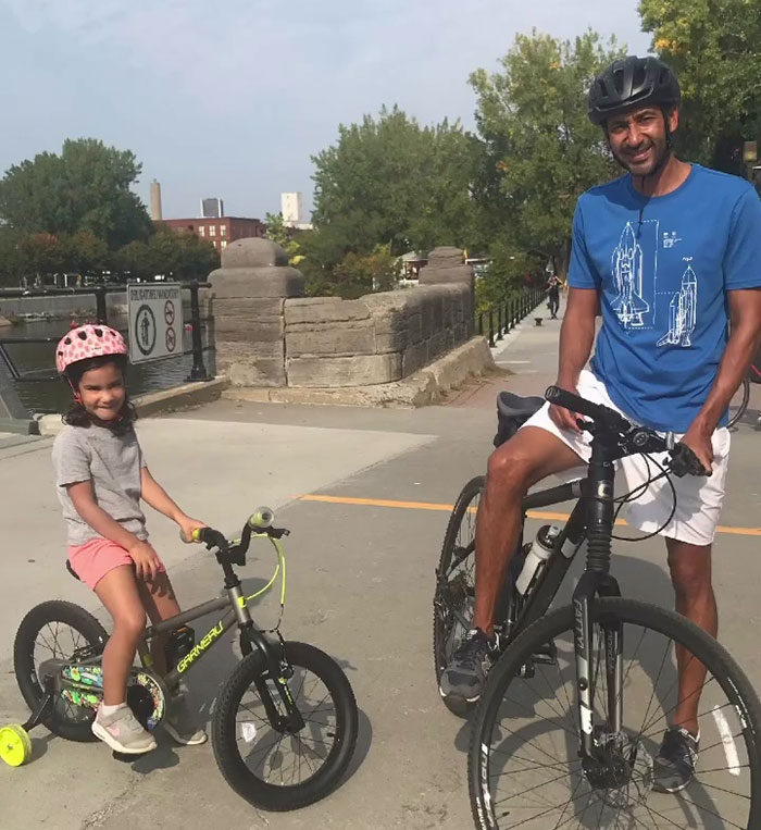 Father and daughter on bicycles by a waterfront, related to police pointing inconsistencies in missing girl report.