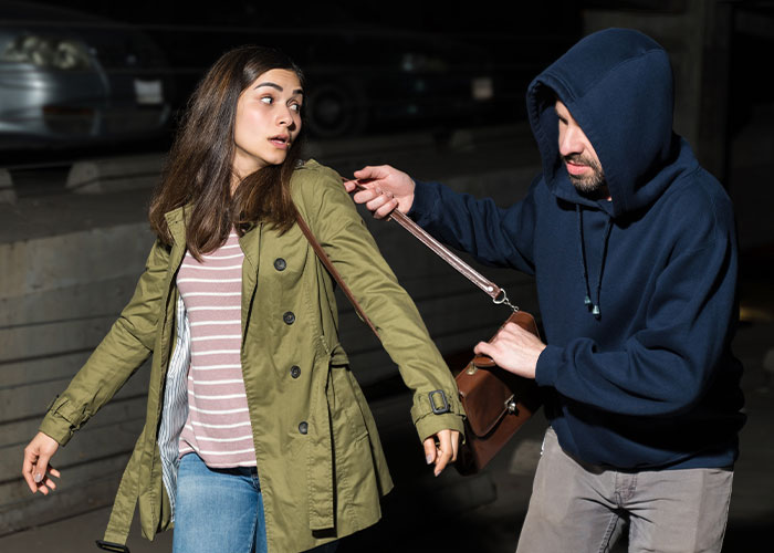 Woman using quick thinking to escape a purse snatching attempt in a dangerous crime situation at night.
