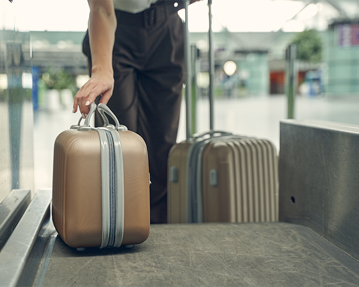 Passenger holding small suitcase at airport luggage check, illustrating Ryanair passenger luggage size dispute issue. - 10
