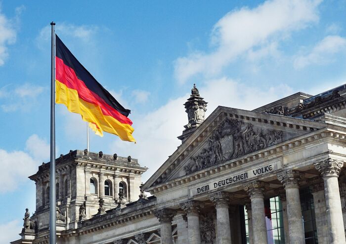 German flag flying over historic government building symbolizing one of the smartest countries shaping the future of the world.