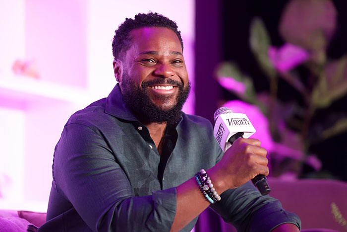 Malcolm-Jamal Warner smiling and holding a microphone during one of his final public appearances at an event. - 1