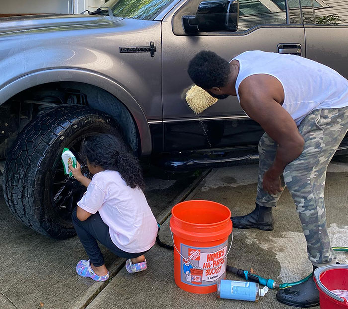 Man and child washing a truck outdoors with cleaning supplies during one of Malcolm-Jamal Warner’s final public appearances - 10