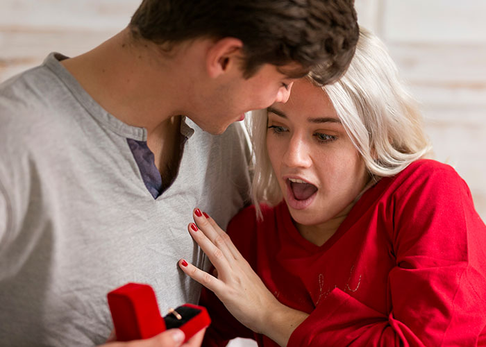 Man surprising woman with ring, her expression shocked and excited, illustrating a man calls his girlfriend sister moment.