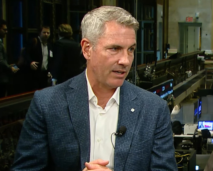 Man in a blue blazer and white shirt sharing a story about a sociopath CEO after Coldplay concert scandal.