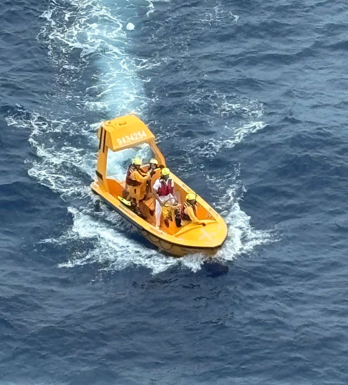 Police rescue team on a small boat conducting a search in ocean waters after viral cruise ship incident.