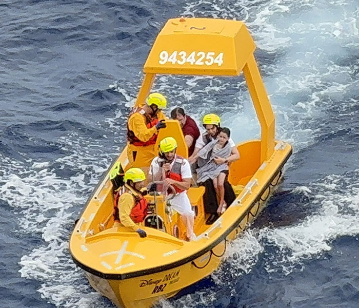 Rescue team in yellow boat on ocean responding to dad who saved daughter after she fell off cruise ship.