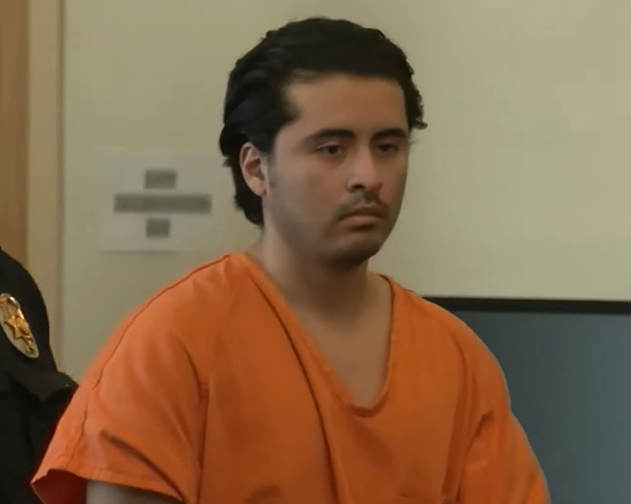 Man in orange prison uniform appearing in court related to slaying his entire family and dog.