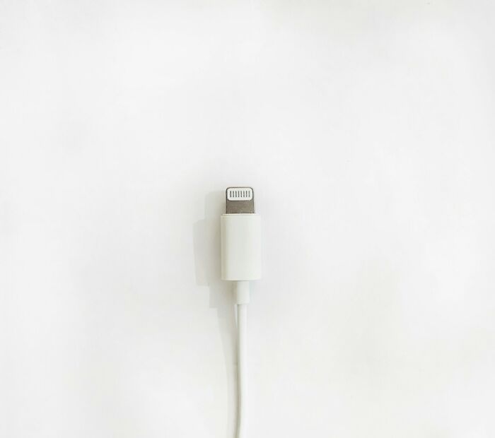 White charging cable connector on a clean white background symbolizing interesting rumors that turned out true.