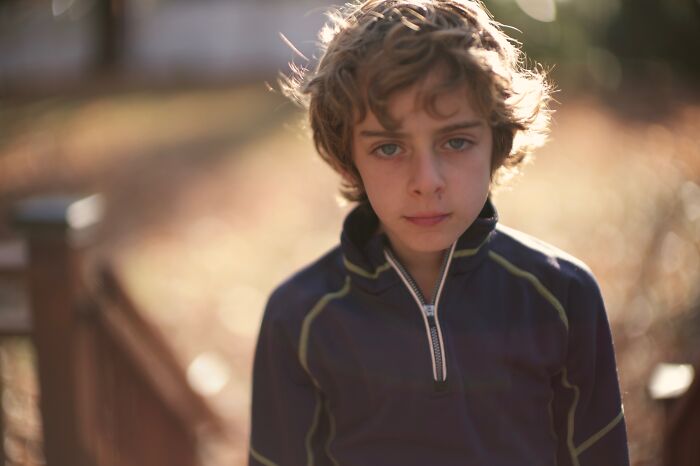 Sad young boy outdoors in soft light reflecting on advice kids were given that revealed manipulation later in life. - 22