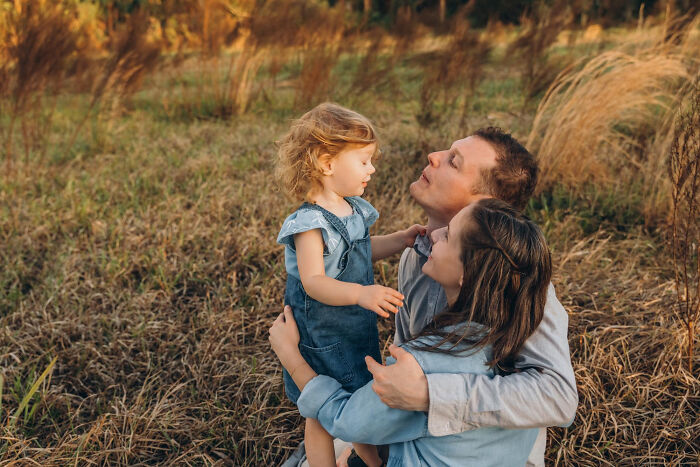 Family embracing in a field, illustrating advice kids were given that they later realized was manipulation in disguise. - 15