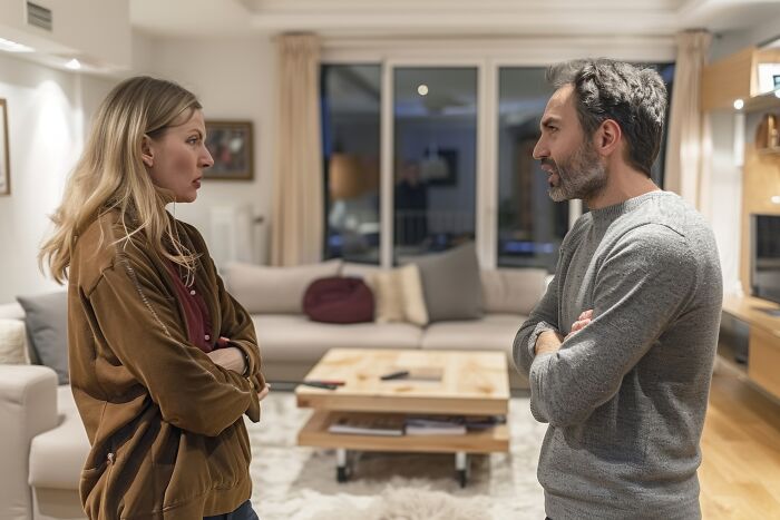 Couple having a tense discussion in a living room, depicting wife’s infidelity as a cause of divorce after 10 years.
