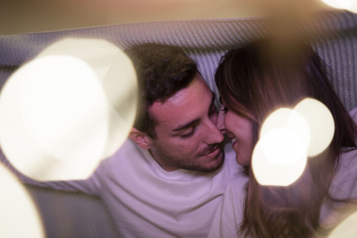 Couple sharing an intimate moment on a couch, illustrating themes of wife's infidelity and marriage struggles leading to divorce.