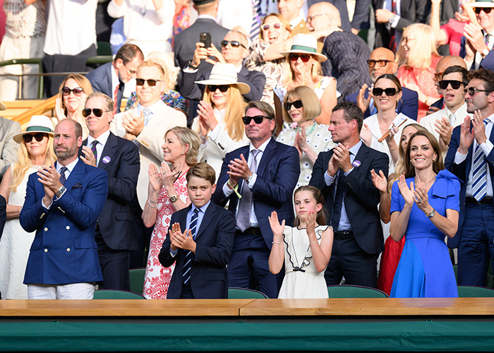 Crowd including Matthew McConaughey applauding British royalty at Wimbledon final during a sunny outdoor event.