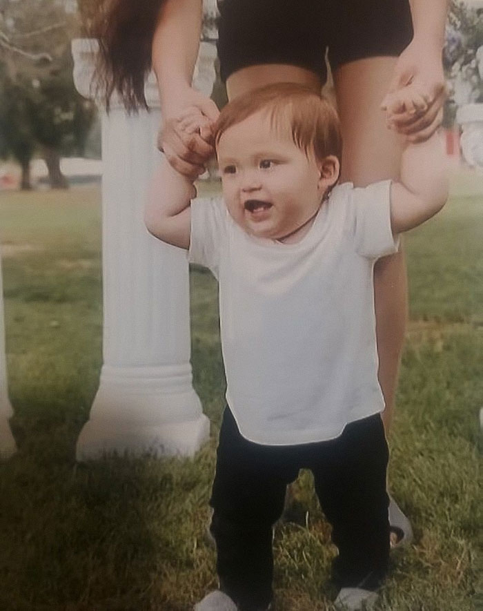 Baby supported by adult hands outdoors, relating to mass outrage over baby left in car to get lip filler. Baby supported by adult hands outdoors, relating to mass outrage over baby left in car to get lip filler.