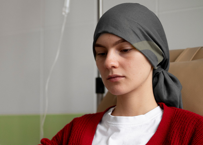Young woman with headscarf receiving medical treatment, appearing thoughtful and affected by gaslighting from a doctor experience.
