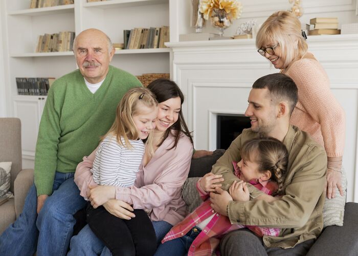 Multigenerational family smiling and hugging in living room, sharing moments that truckers share craziest things seen. - 25