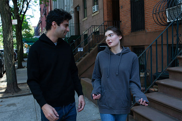 A man and woman talking on a city sidewalk, illustrating men explaining things that drives wife crazy.