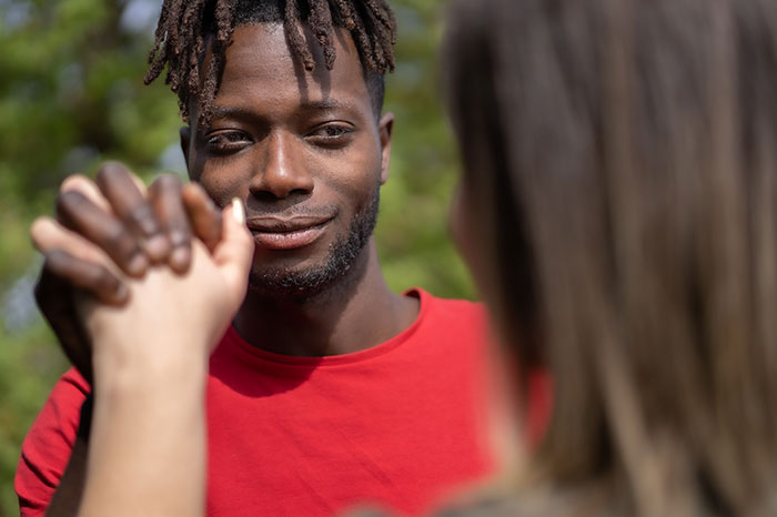 Man in a red shirt engaging with a woman, illustrating things men shouldn’t do while pursuing women according to online advice. - 20