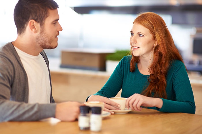 A man and woman having coffee and talking, illustrating common mistakes men should avoid while pursuing women. - 7