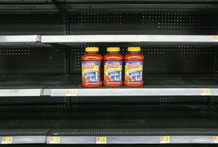 Three jars of pasta sauce on mostly empty grocery shelves, illustrating surprising things travelers see when visiting the U.S.
