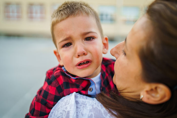Woman caregiver comforting a crying child outdoors after replacing MIL amid allergy incidents and family conflicts.