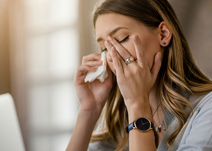 Woman battling cancer wiping tears with tissue, showing emotional struggle while asking for help at home. - 1