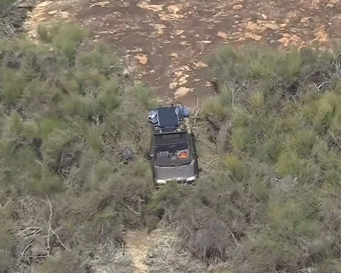 Aerial view of search vehicle in dense Australian outback vegetation during backpacker missing person rescue operation.