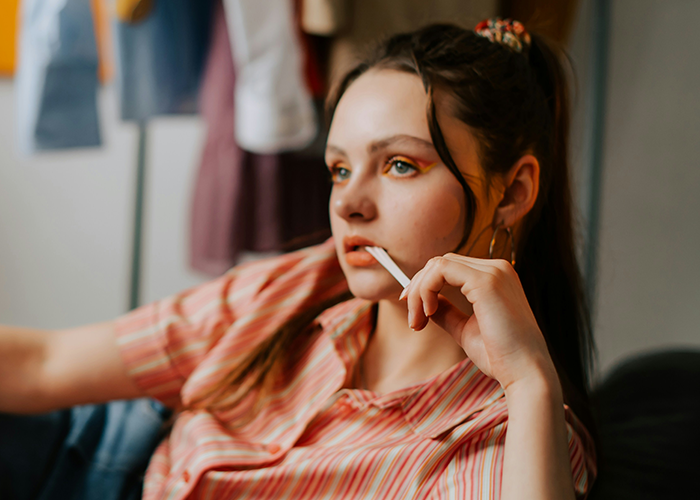 Young woman with thoughtful expression sitting indoors, reflecting on a difficult relationship with unhinged stepfather. Young woman with thoughtful expression sitting indoors, reflecting on a difficult relationship with unhinged stepfather.