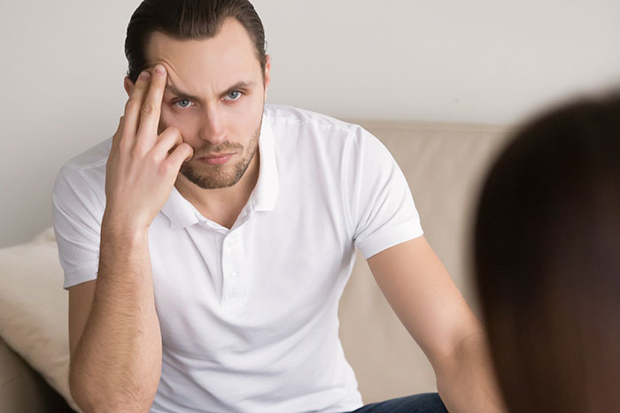 Man in white shirt with a serious expression, portraying a tense moment during real-life encounters with psychopaths. - 4