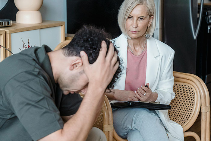 Therapist listening attentively to distressed man during real-life encounters with psychopaths in a counseling session. - 17