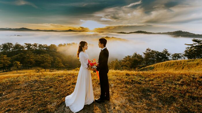 Bride and groom standing outdoors at sunset, sharing a moment during a second, third, or seventh wedding ceremony. - 15
