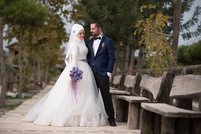 Bride and groom in traditional wedding attire posing outdoors, illustrating stories of attending multiple weddings of the same person. - 23