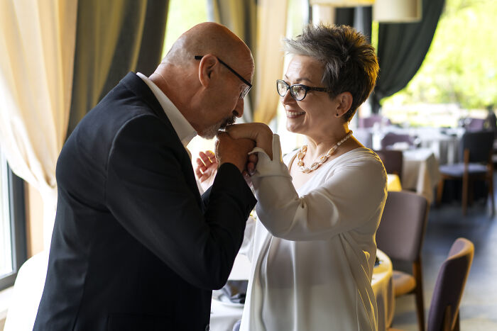 Couple celebrating a wedding moment indoors, highlighting stories of attending the same person’s multiple weddings. - 30